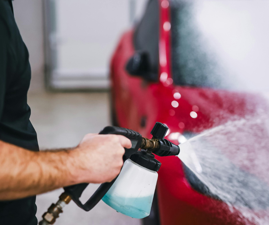 A worker applying ceramic coating in San Antonio to a car's exterior